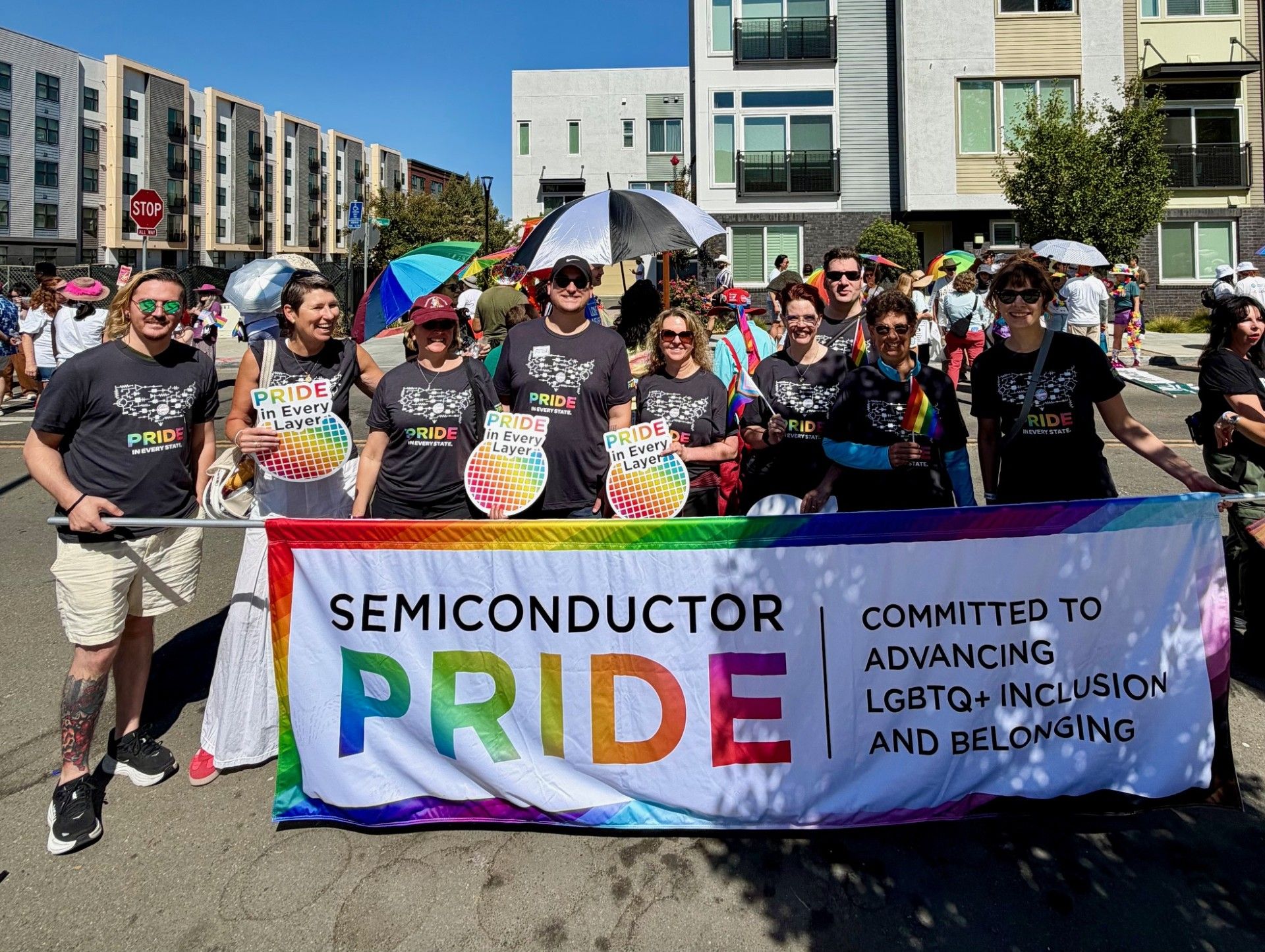 Semiconductor PRIDE members marching behind their banner at a 2026 Pride parade
